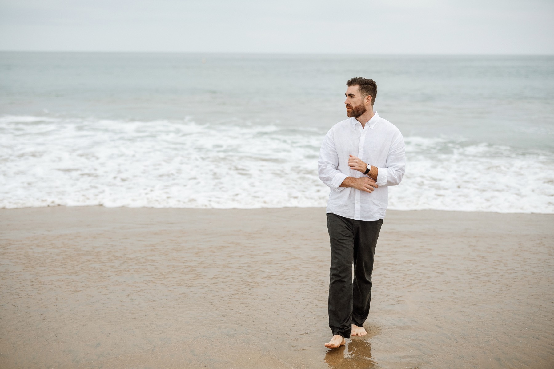 Jordan Felix walking along the shoreline, looking out at the ocean